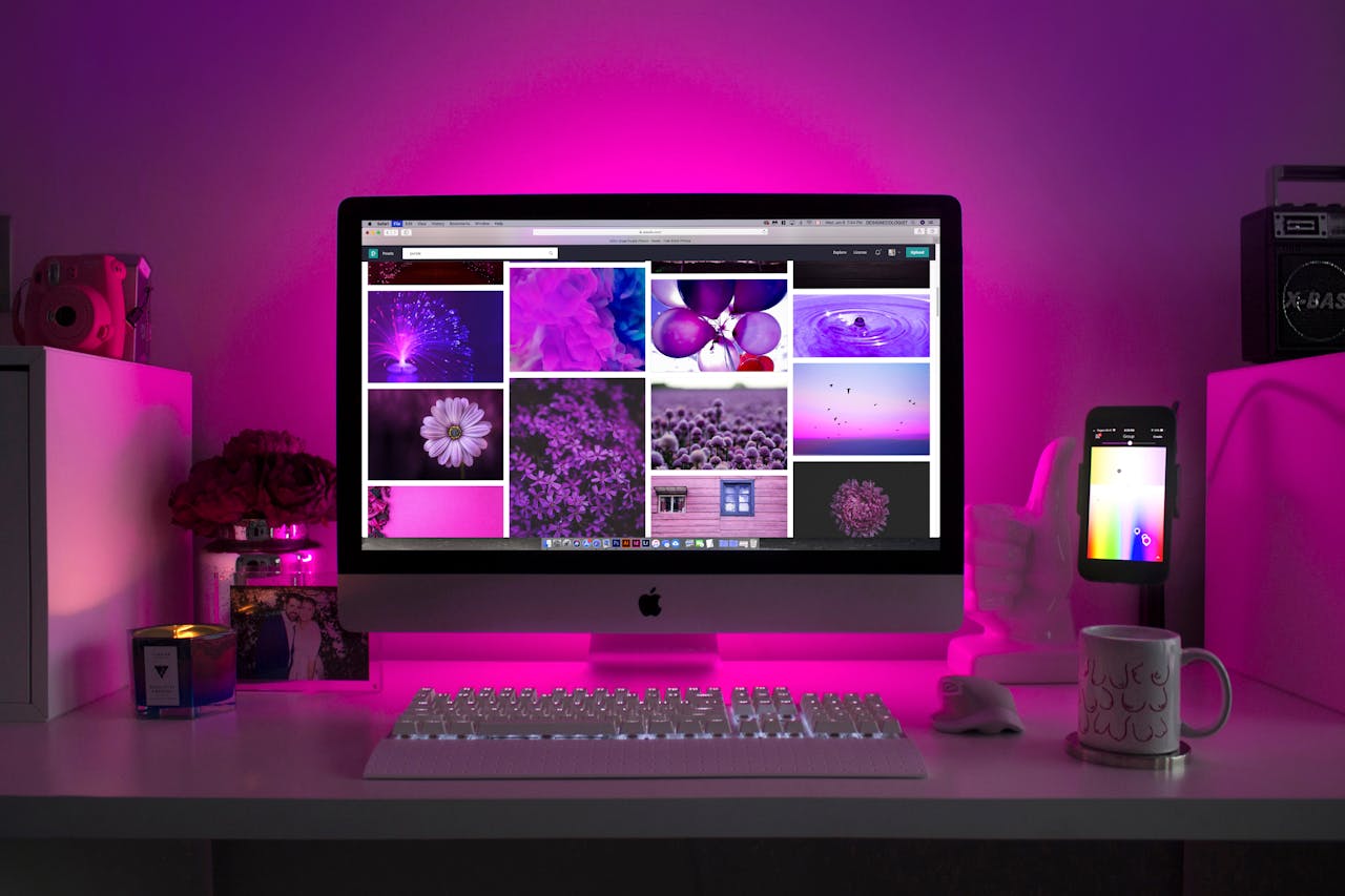 our-services-1 Modern desk setup with neon lighting and a desktop computer displaying colorful images.